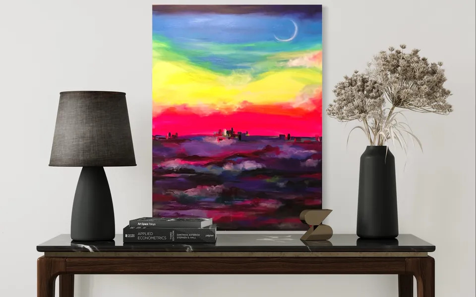 A vertical sunset seascape by Yana Yank in yellow, magenta and violet above a console table with a black lamp